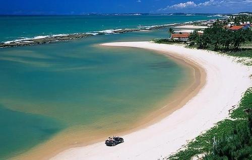 a boat on a beach near the water at Tabatinga Beach Hotel in Nísia Floresta