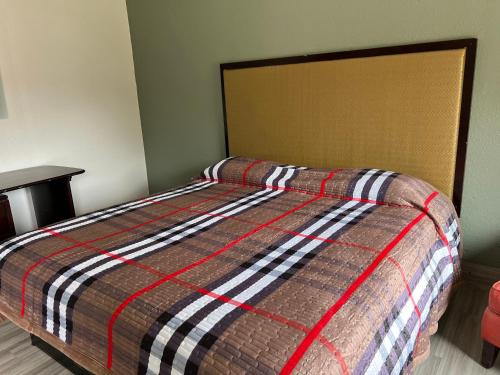 a bed with a striped comforter in a bedroom at Comfort stay inn in Quincy