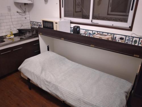 łóżko w kuchni ze zlewem i kuchenką mikrofalową w obiekcie Tren Del Desierto w mieście Villa Unión
