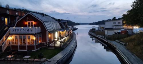 a building next to a river at night at Villa Strömma Värmdö - Sthlm archipelago, comfortable & fully equipped, 35 min from city center in Värmdö