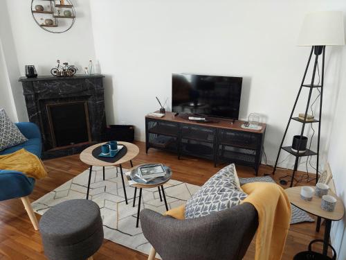 a living room with a couch and a tv at Les Minimes in Issoudun