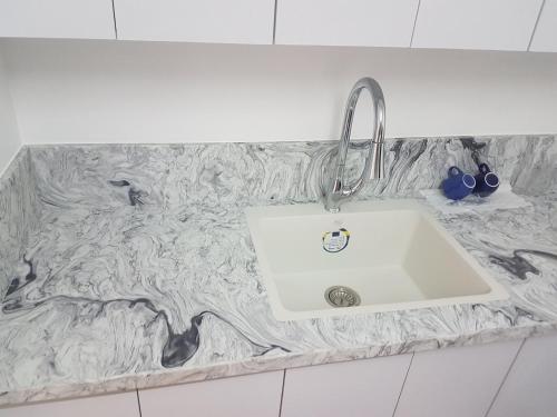 a sink in a bathroom with a marble counter top at Gilad in Qiryat Yam