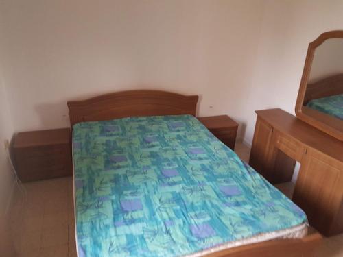 1 dormitorio con 1 cama con edredón verde y azul en Gilad, en Qiryat Yam