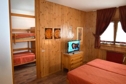 a bedroom with two beds and a television in it at Hostel San Matteo in Santa Caterina Valfurva