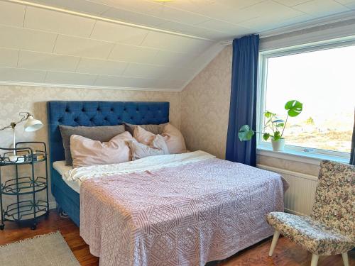 a bedroom with a bed and a chair and a window at Lysekil sunset Villa in Lysekil