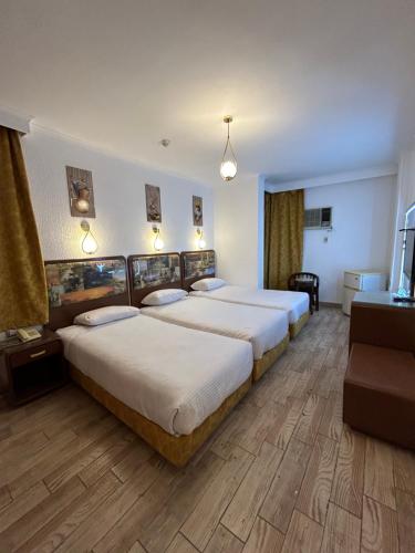 a hotel room with two beds and a television at Oasis Hotel Heliopolis in Cairo