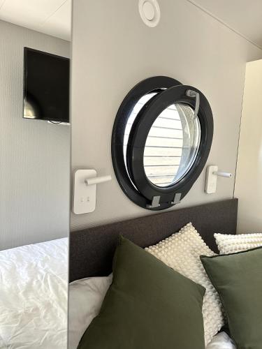 a bedroom with a mirror above a bed at La Mare Resort in Gothenburg