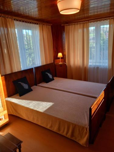 um quarto com uma cama grande e 2 janelas em Dom w Skrzydlnej em Skrzydlna