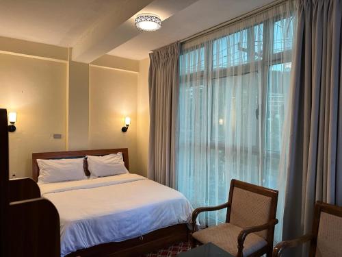 ein Hotelzimmer mit einem Bett und einem Fenster in der Unterkunft Keba Guest House in Addis Abeba