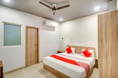 um quarto com uma cama com almofadas vermelhas em OYO Flagship JPS Grand Hotel em Nova Deli