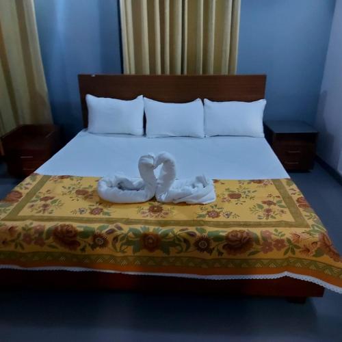 a bed with two towels on it with a bed at Orina Hotel in Colombo