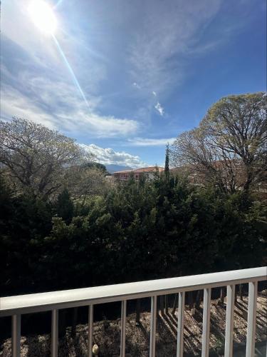 a view from a balcony of trees and the sun at Acapella Hotel in Argelès-sur-Mer