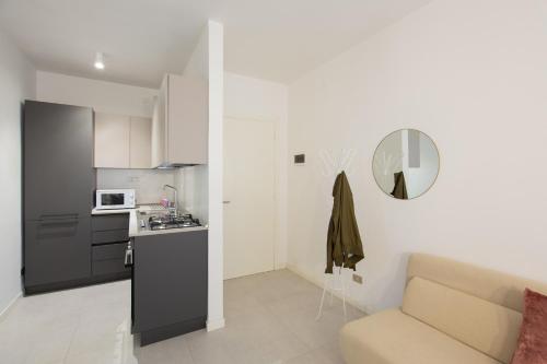 een keuken en een woonkamer met een bank bij VIRGINIA APPARTAMENTI RICCIONE in Riccione