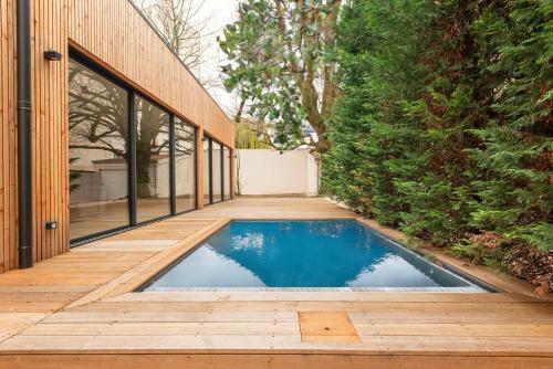 a swimming pool on a wooden deck next to a house at Villa Marie in Dijon