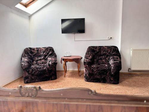 2 sillas y una mesa en una habitación con TV en Complex Select en Mediaş