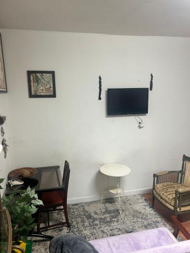 a living room with a tv on a white wall at Charming Studio Flat Near Center City in Philadelphia