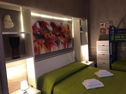 a bedroom with a green bed with two towels on it at Villa Tellina Mare Luna in Granelli