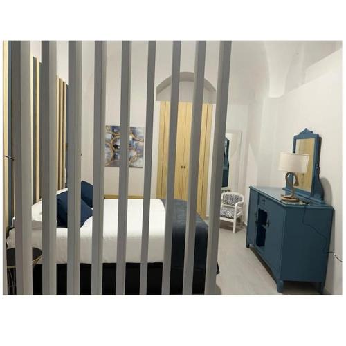 1 dormitorio con cuna y armario azul con cama en Apartamento Las Bóvedas, en Cáceres