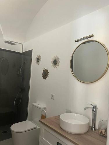 baño con lavabo y espejo en la pared en Apartamento Las Bóvedas, en Cáceres