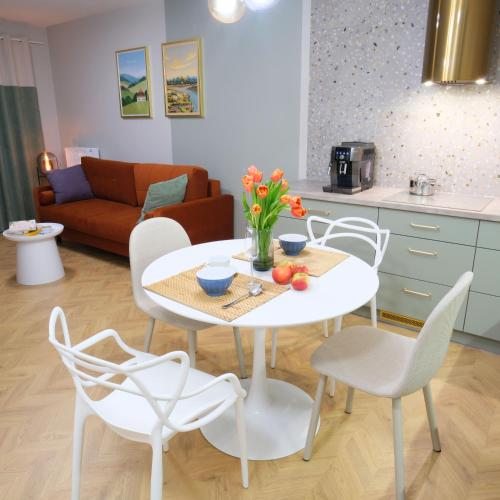 uma sala de estar com uma mesa branca e cadeiras em Apartament Andersa Biłgoraj parking podziemny em Bilgoraj