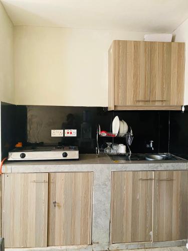 a kitchen with wooden cabinets and a counter top at Tsavo Studios Apartment in Nairobi