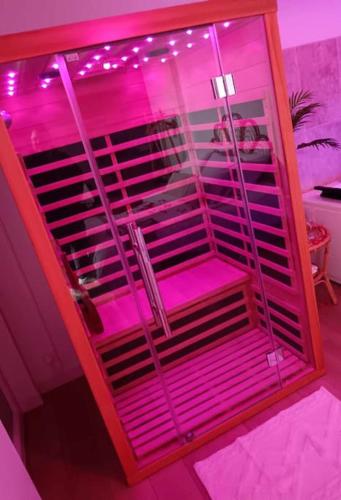 une chambre rose avec une cage aux lumières roses dans l'établissement Toi et moi à 8 min d etretat, à Gerville