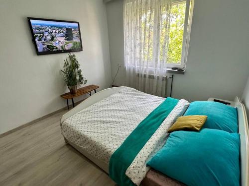 - une chambre avec un lit et une télévision murale dans l'établissement Sunny Apartment in Silesia, à Czeladź