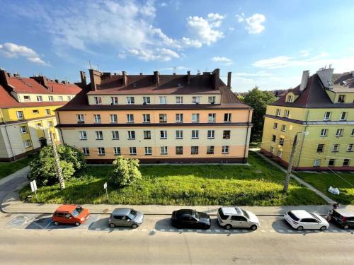 a group of cars parked in a parking lot in front of a building at Sunny Apartment in Silesia in Czeladź