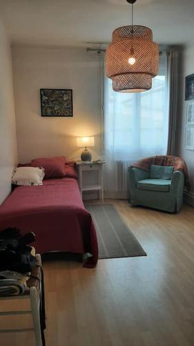 une chambre avec un lit, une chaise et une fenêtre dans l'établissement Flat with private parking, in the heart of Sete, à Sète