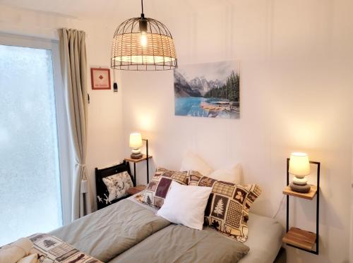 een slaapkamer met een bed en een hanglamp bij Moonshine Érd in Érd