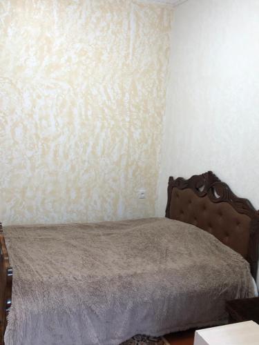 a bedroom with a bed with a brown head board at Sweet house in Gyumri