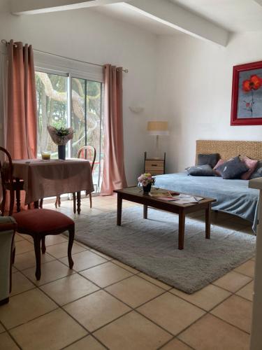 ein Wohnzimmer mit einem Bett und einem Tisch in der Unterkunft Mas de la pie in Saintes-Maries-de-la-Mer
