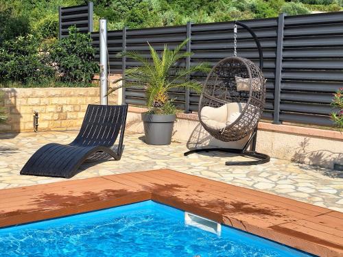 a swing and a chair next to a pool at Apartment Maja with private pool in Sveti Petar