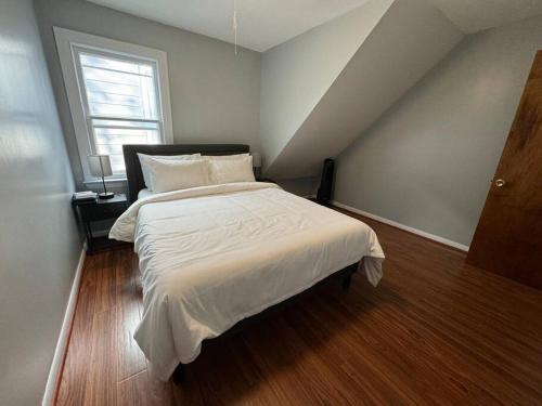 a bedroom with a bed with white sheets and a window at Comfy getaway full Apt single bedroom sleeps two! in Niagara Falls