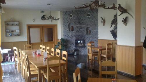 a restaurant with a table and chairs and a fireplace at Penzion Tetřívek in Nové Hutě