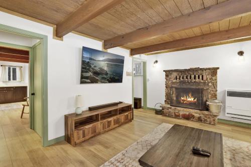 een woonkamer met een open haard en een tafel bij 2424-Midnight Pines cabin in Big Bear Lake