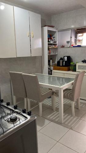 a kitchen with a table and chairs and a stove at Quarto em stella maris in Salvador