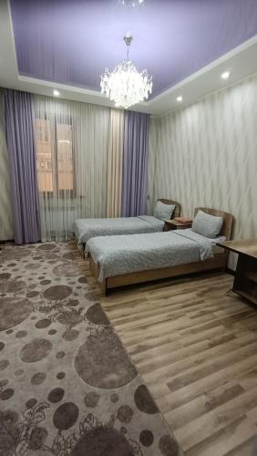 a bedroom with two beds and a chandelier at Отель Чынгыз 2 in Osh