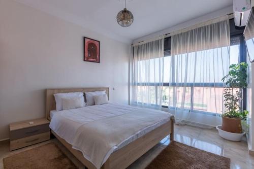 ein Schlafzimmer mit einem großen Bett und einem großen Fenster in der Unterkunft Appartement Authentique au Centre in Marrakesch