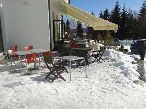 a group of tables and chairs in the snow at Penzion Tetřívek in Nové Hutě