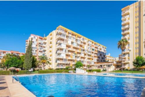 une grande piscine devant certains bâtiments dans l'établissement Hércules Nuevo y Moderno Estudio, à Benalmádena