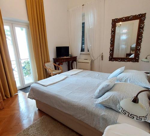 1 dormitorio con 1 cama grande y espejo en Apartments Batala, en Dubrovnik