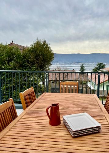 - une table en bois avec une plaque de cuisson et une tasse sur le balcon dans l'établissement Maison Veyrier du Lac, à 10 min à pied de la plage, à Veyrier-du-Lac