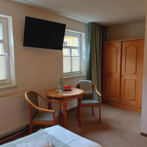 a room with a table and chairs and a television at Bed and Breakfast Wehlen in Stadt Wehlen