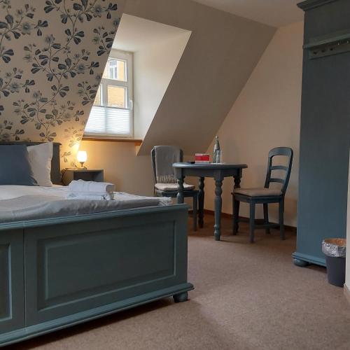 a bedroom with a bed and a table and chairs at Bed and Breakfast Wehlen in Stadt Wehlen