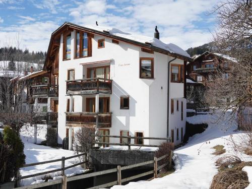 ein Haus im Winter mit Schnee auf dem Boden in der Unterkunft Casa Seraina - im Herzen von Flims in Flims