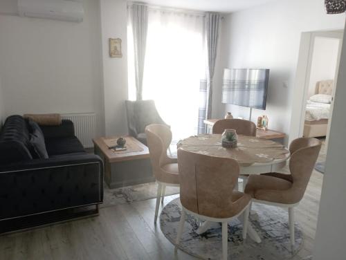 a living room with a table and chairs and a couch at Apartmani Dar Lux in Banja Koviljača