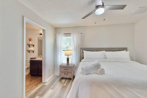 - une chambre blanche avec un lit et un ventilateur de plafond dans l'établissement Brooksville Retreat! 3 Bed, 2 Bath!, à Brooksville