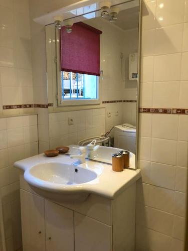 une salle de bain avec un lavabo et un miroir dans l'établissement Havre de paix Provencal, à Bandol