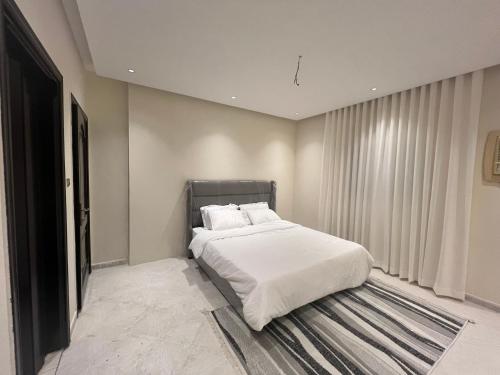 a bedroom with a bed and a large window at شقة3 غرف نوم في حي الروضة in Jeddah